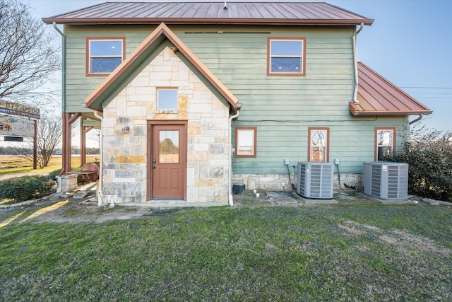 rear view of house featuring a yard and central air condition unit