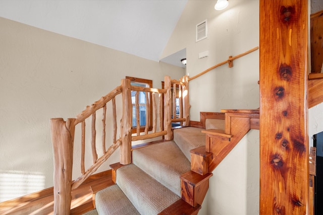 staircase featuring lofted ceiling and hardwood / wood-style floors