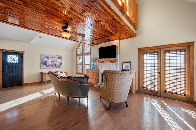 interior space with hardwood / wood-style flooring, a fireplace, high vaulted ceiling, and french doors