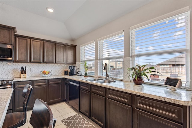 kitchen with light tile patterned flooring, appliances with stainless steel finishes, tasteful backsplash, sink, and dark brown cabinetry