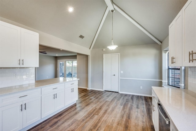 kitchen featuring white cabinetry, decorative light fixtures, lofted ceiling, and stainless steel dishwasher