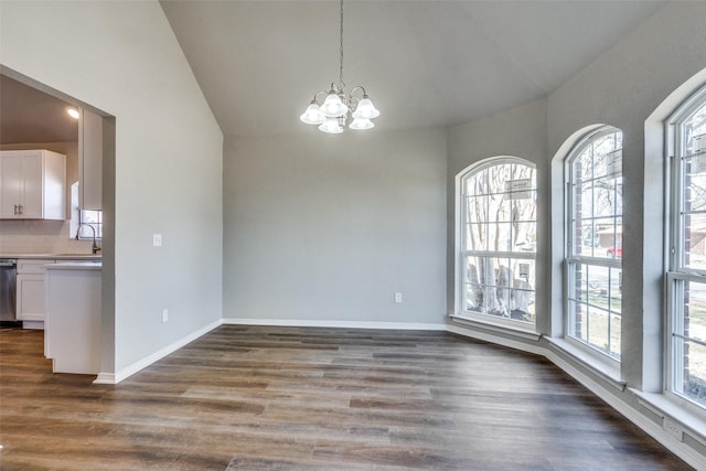 unfurnished dining area featuring a wealth of natural light, sink, an inviting chandelier, and dark hardwood / wood-style floors