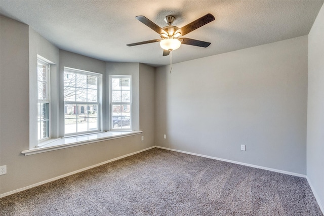 carpeted empty room with ceiling fan and a textured ceiling