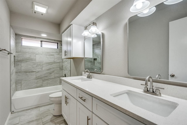 full bathroom featuring tiled shower / bath combo, vanity, and toilet