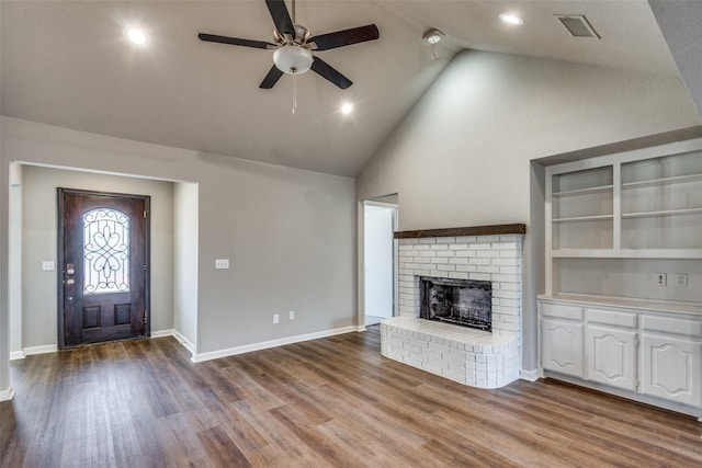 unfurnished living room featuring built in shelves, high vaulted ceiling, ceiling fan, a fireplace, and hardwood / wood-style floors