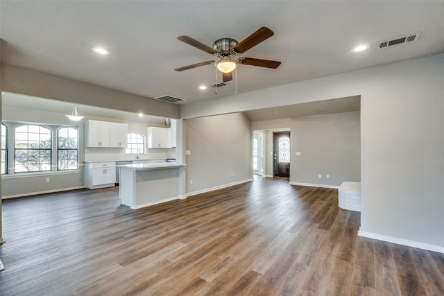 kitchen with white cabinetry, ceiling fan, kitchen peninsula, and dark wood-type flooring