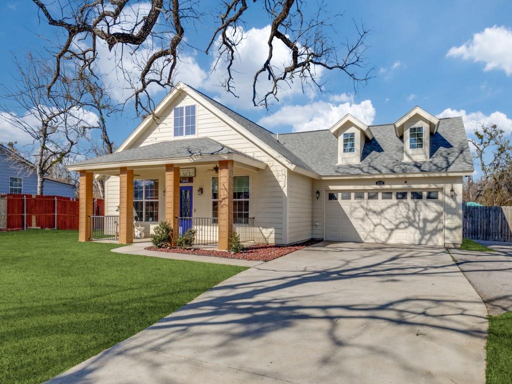 view of front of property with a garage, a front yard, and covered porch