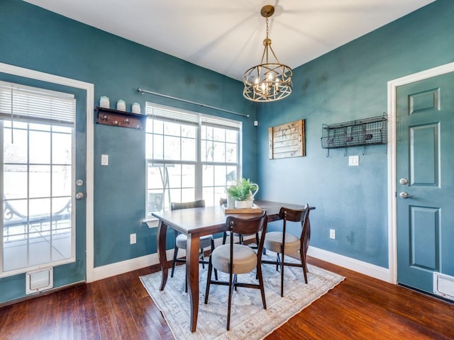 dining room featuring a healthy amount of sunlight, a chandelier, and dark hardwood / wood-style floors