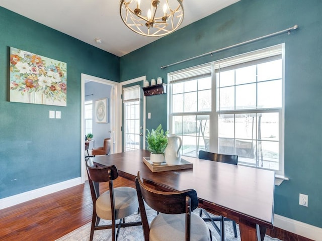 dining area with hardwood / wood-style flooring and a chandelier