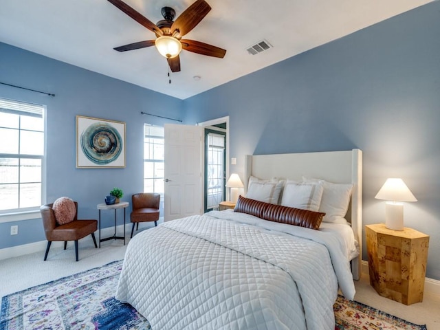 bedroom with multiple windows, ceiling fan, and carpet