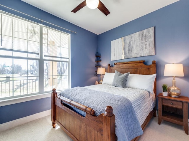 carpeted bedroom with ceiling fan and multiple windows