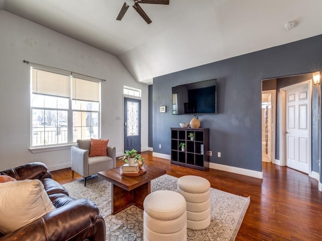 living room featuring dark wood-type flooring, ceiling fan, and vaulted ceiling