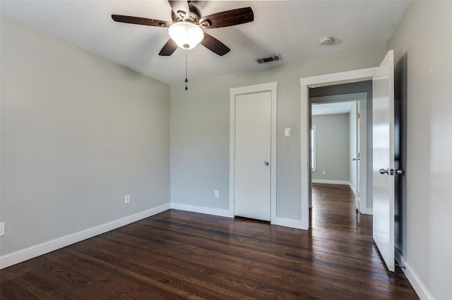 unfurnished bedroom featuring dark hardwood / wood-style floors and ceiling fan