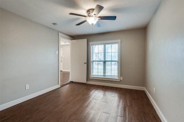 unfurnished room with dark wood-type flooring and ceiling fan