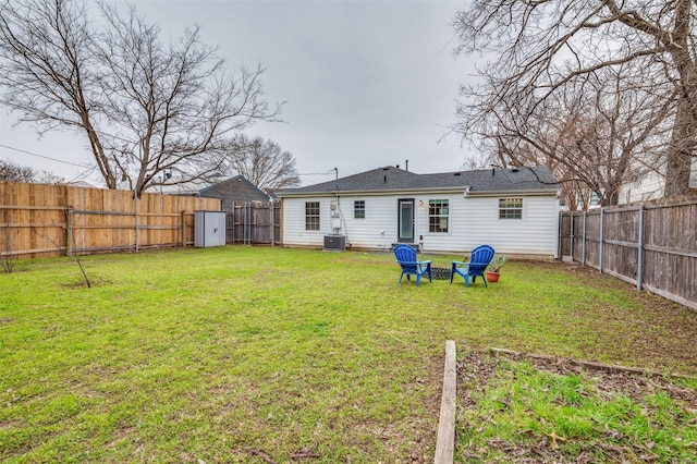 back of property featuring cooling unit, a yard, and a shed