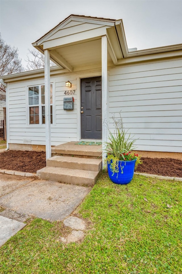 doorway to property with a yard