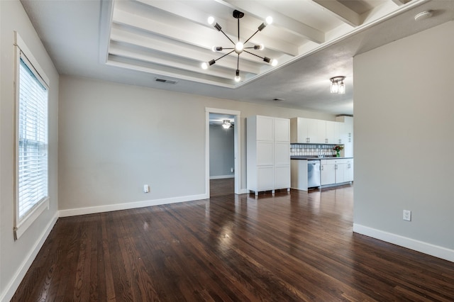 unfurnished living room featuring beamed ceiling, a raised ceiling, dark wood-type flooring, and a notable chandelier