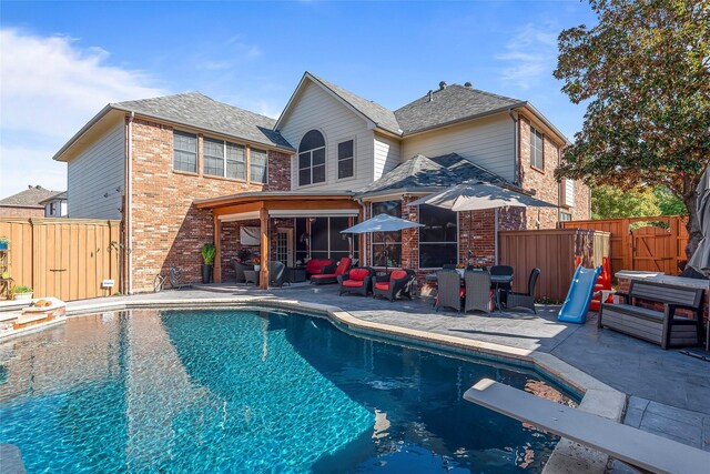 view of swimming pool featuring a diving board and a patio area