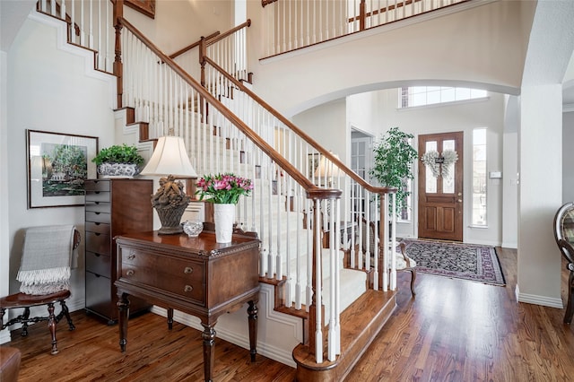 entrance foyer with a towering ceiling and hardwood / wood-style floors