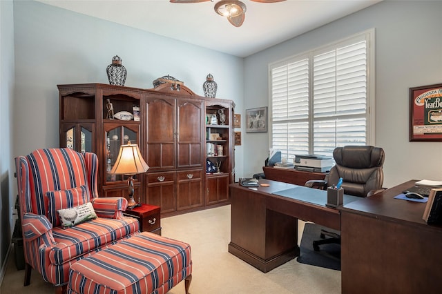 carpeted home office featuring ceiling fan