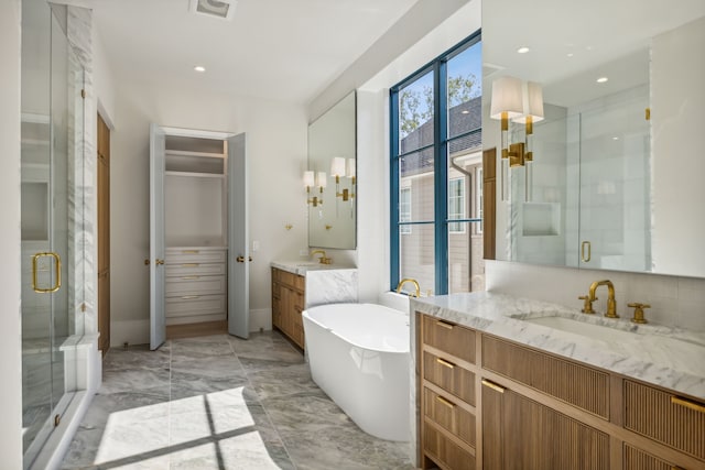 bathroom with vanity and shower with separate bathtub