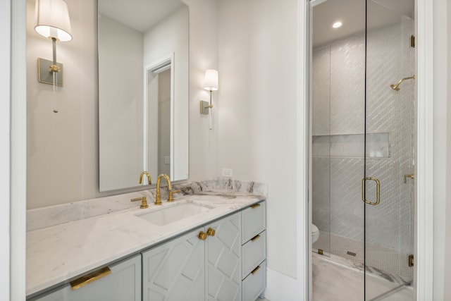 bathroom featuring a shower with door and vanity