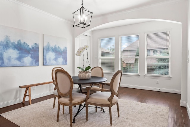 dining room featuring hardwood / wood-style flooring, ornamental molding, and an inviting chandelier