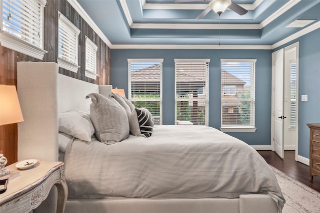 bedroom featuring hardwood / wood-style floors, a tray ceiling, and ornamental molding