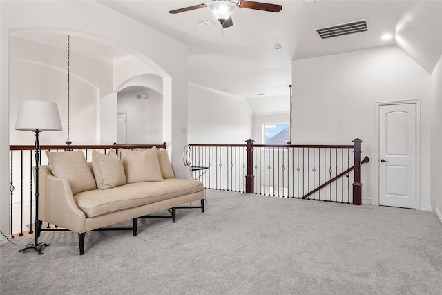 living area with lofted ceiling, ceiling fan, and carpet flooring