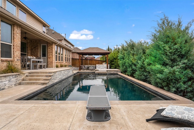 view of pool with a gazebo, a diving board, and a patio