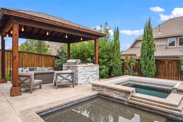 view of patio with a gazebo, outdoor lounge area, an in ground hot tub, a grill, and exterior kitchen