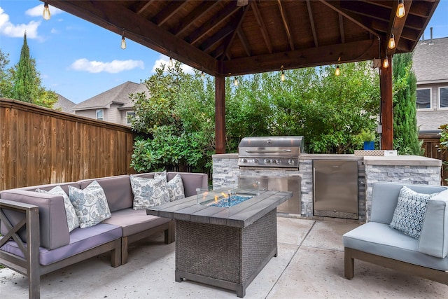 view of patio with a gazebo, grilling area, an outdoor fire pit, and an outdoor kitchen