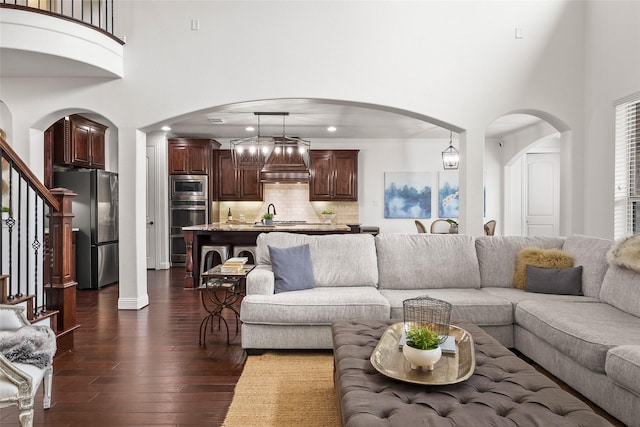 living room featuring dark wood-type flooring and a towering ceiling