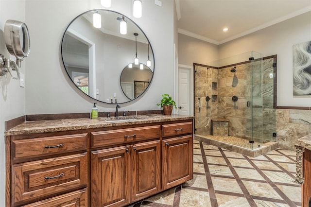 bathroom featuring crown molding, vanity, and a shower with shower door