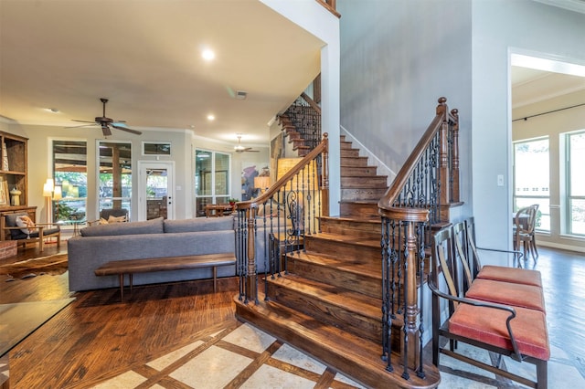 staircase featuring crown molding and ceiling fan