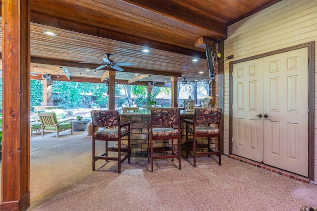 dining space featuring wood ceiling, ceiling fan, carpet, and beamed ceiling