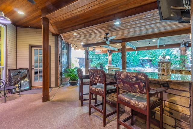 view of patio with ceiling fan and a bar