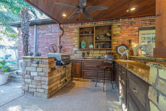 view of patio with grilling area, ceiling fan, and an outdoor kitchen