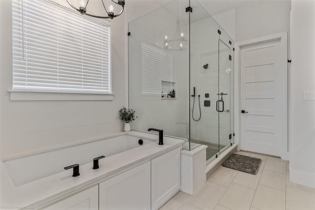 bathroom with a chandelier, a shower stall, a bath, and tile patterned flooring