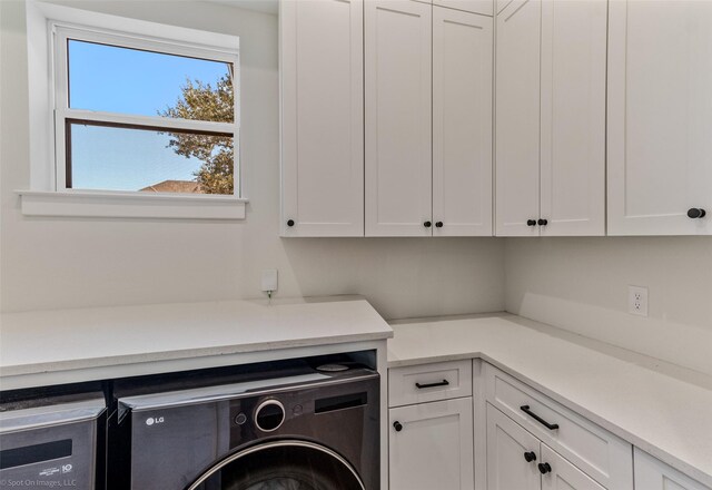 washroom featuring washer / clothes dryer and cabinet space