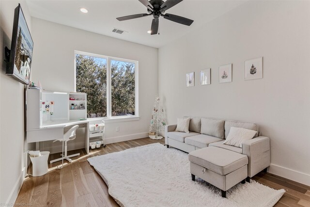 living area featuring wood finished floors, visible vents, and baseboards
