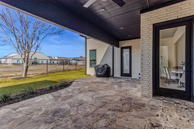 view of patio with ceiling fan, an attached carport, and fence
