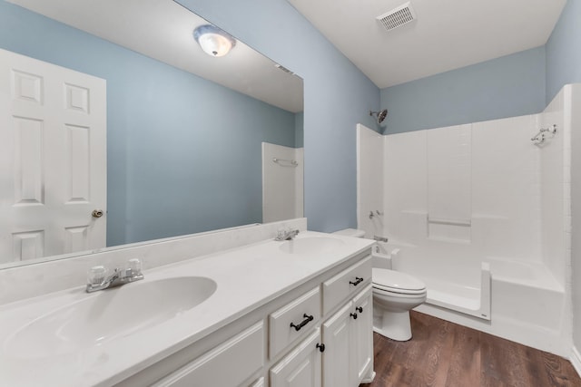 full bathroom featuring vanity, hardwood / wood-style floors, tub / shower combination, and toilet