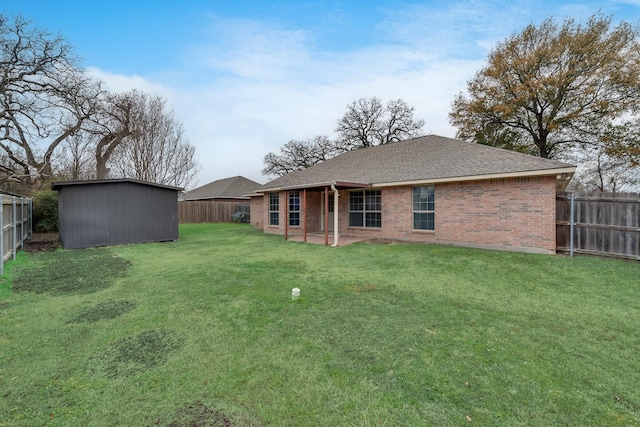 back of house featuring a patio, a yard, and a storage unit