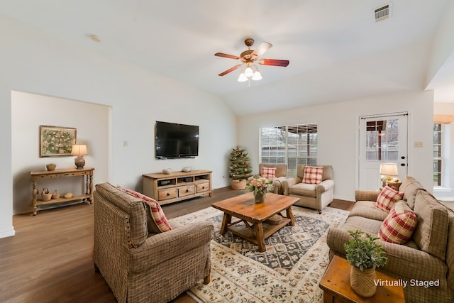 living room with hardwood / wood-style flooring, ceiling fan, and vaulted ceiling