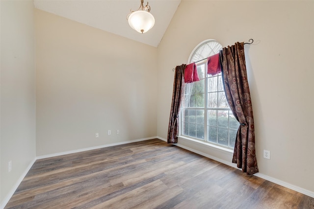 spare room featuring hardwood / wood-style flooring, plenty of natural light, and vaulted ceiling