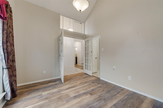 unfurnished bedroom featuring light hardwood / wood-style floors and a high ceiling