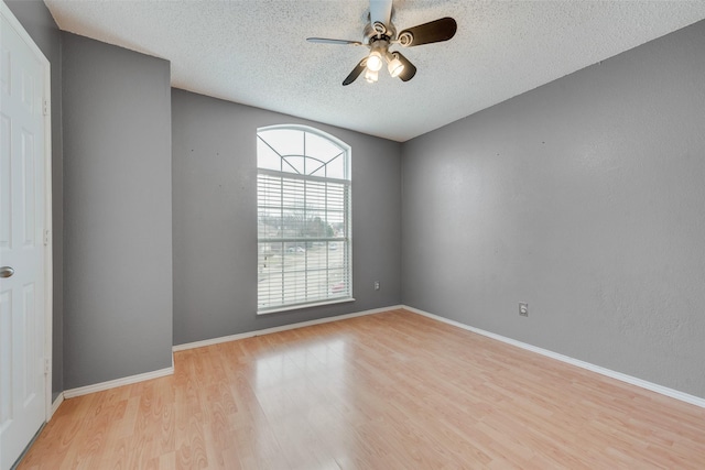 spare room with ceiling fan, light hardwood / wood-style flooring, and a textured ceiling