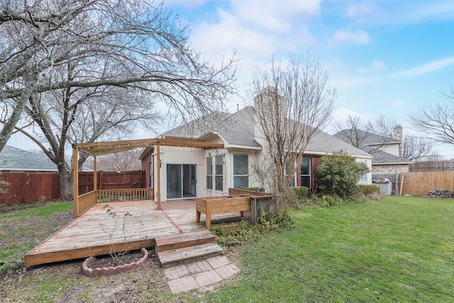 rear view of house featuring a wooden deck and a lawn