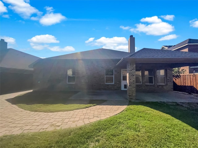 back of house with a patio area and a lawn